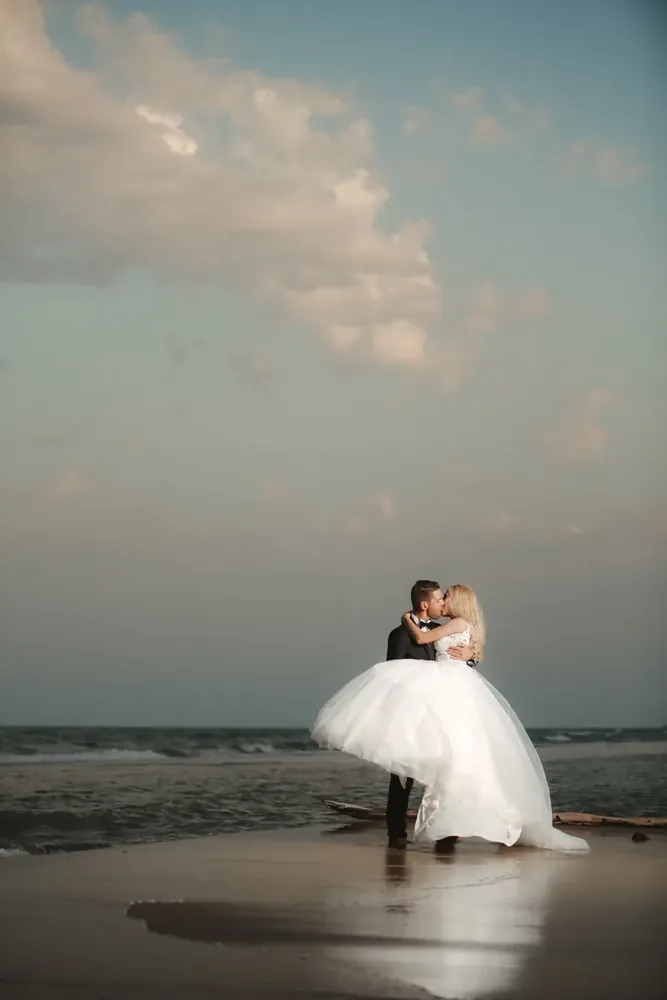 Brautpaar küsst sich am Strand – Hochzeitsfotos am Meer